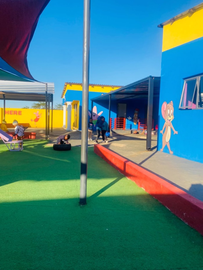 Children playing with a tyre on the green turf